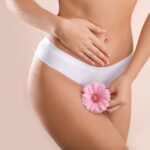 Eine Frau im Slip hält eine Blume