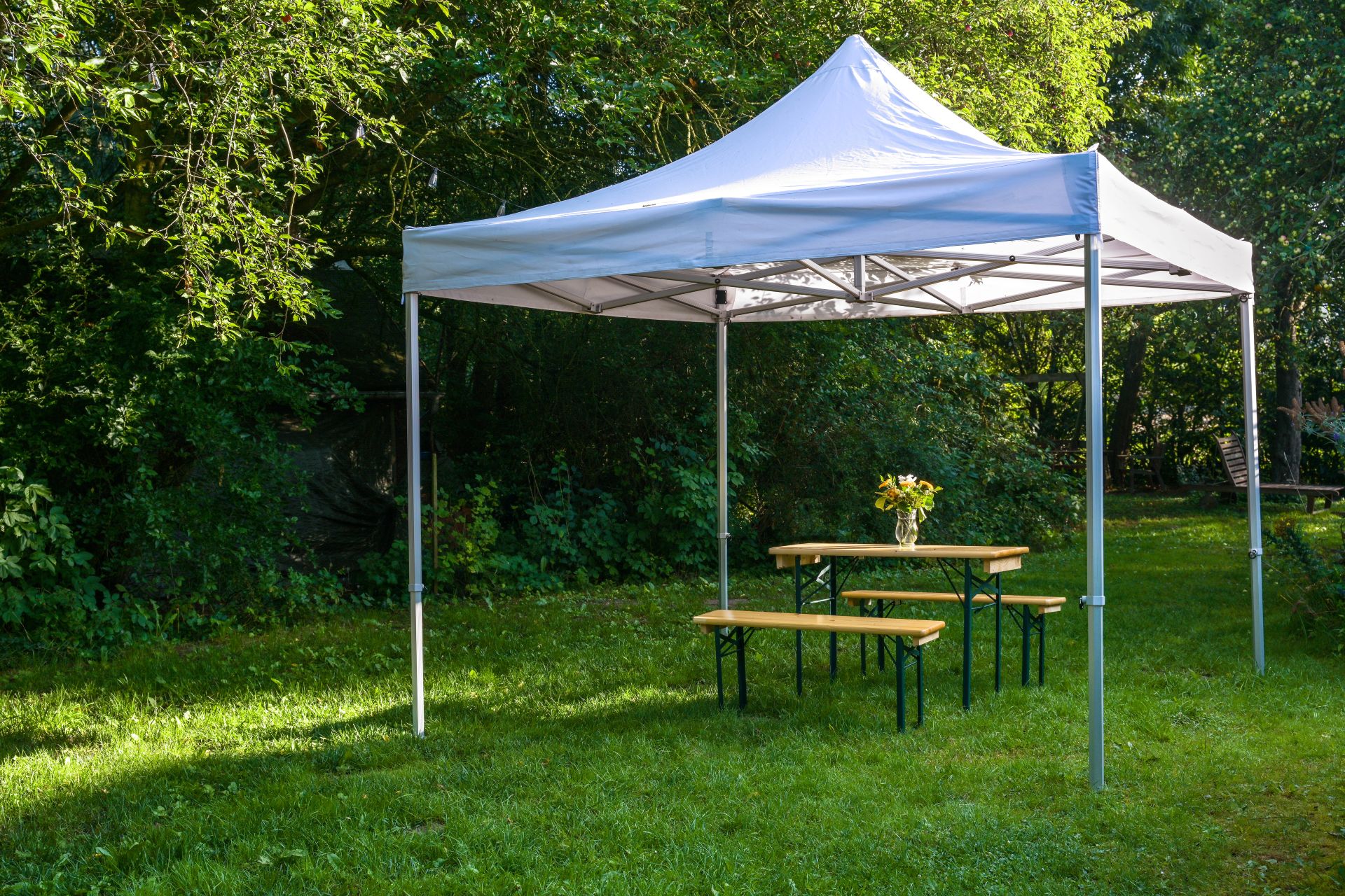Offener gartenpavillon mit weissen vorhaengen und sitzgelegenheiten im sommer, dekorativ und wetterfest